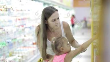 妈妈带坐在<strong>购物车</strong>的宝宝在超市挑选商品